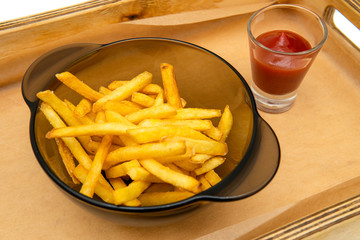 Golden French fries potatoes ready to be eaten. French fries with ketchup on white background.