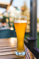 A glass of beer on a wooden table in a restaurant