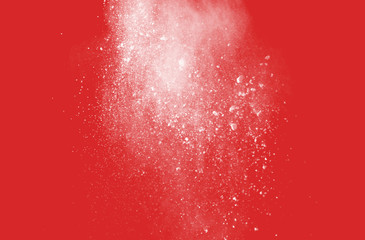 Explosion of colored powder on redbackground