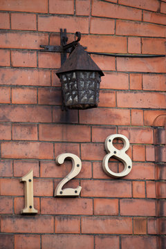 Brick wall with brass numbers sign