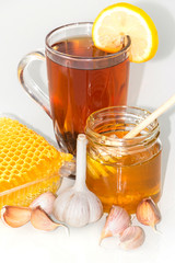 Tea with lemon and honey, garlic cloves. The honey in the comb.