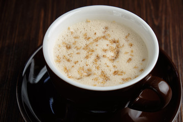 Cappuccino on a brown wooden background. Menu