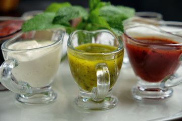sauces in bowls on a dark wooden background. menu for catering