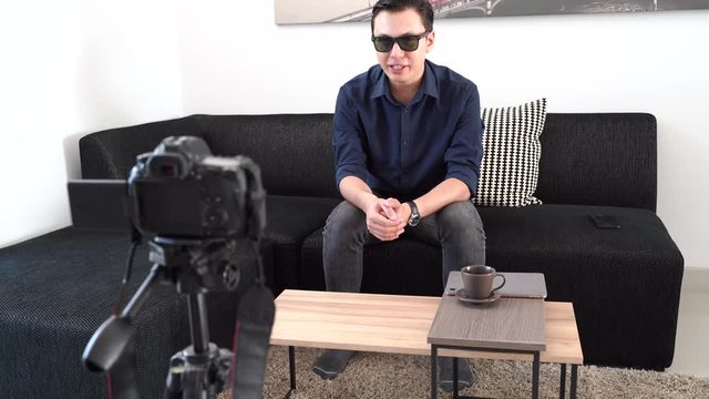 Young asian man vlogging and recording video at home with camera, lifestyle and live streaming concept