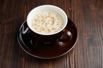Cappuccino on a brown wooden background. Menu