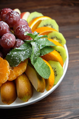 Sliced fruits on a white plate . catering menu