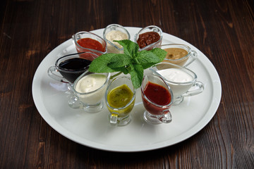 sauces in bowls on a dark wooden background. menu for catering