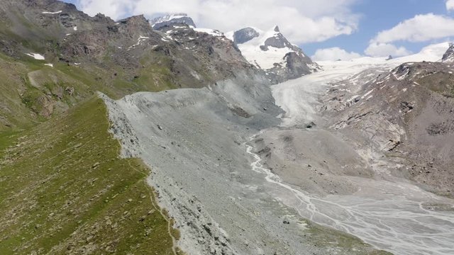 Aerial lateral flight overflying Findelgletscher moraine, descending towards Findelgletscher glacier. Zermatt, Switzerland