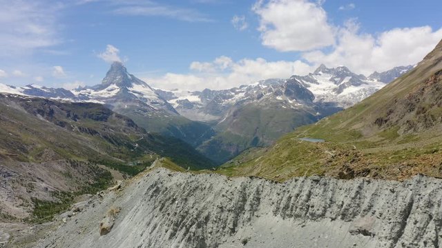 Aerial lateral flight climbing over Findelgletscher glacier moraine, Matterhorn summit in background. Zermatt, Switzerland