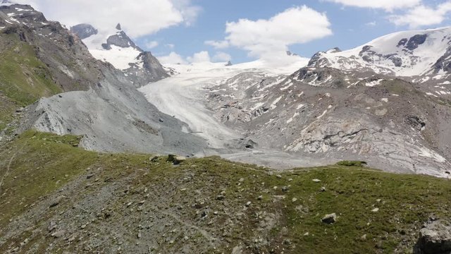 Aerial passing low over lateral moraine, revealing Findeln glacier. Zermatt, Switzerland