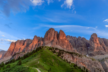 A stunning sunset view of the Dolomites Alps painted red from the setting sun. (View from a top place for shooting sunset in the Dolomites) Italian Dolomites, Alto Adige, Colfosco.