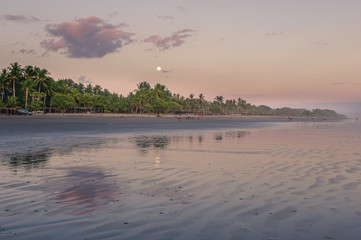 Moon over the beach at a sunset
