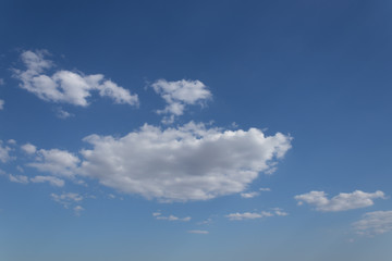 transparent atmospheric layer with blue sky and soft fluffy clouds of white color.