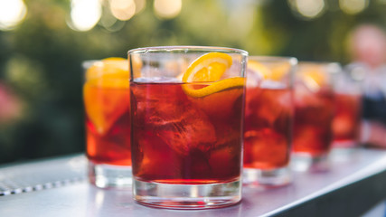 Close-up of colorful exotic cocktail stand on the bar, outdoors. Concept about drink, alcohol and restaurant service