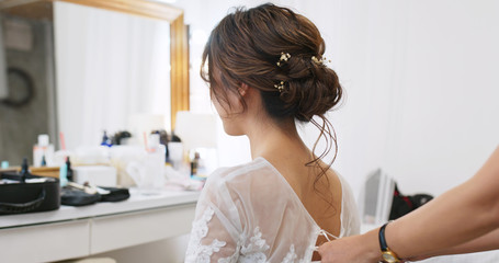 Hairdresser creating a hairstyle for female model in salon