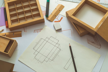 Development design drawing packaging. Desktop of a creative person making cardboard boxes. - 290793148