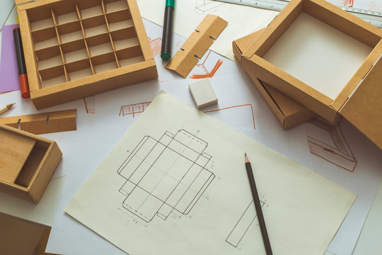 Development design drawing packaging. Desktop of a creative person making cardboard boxes.