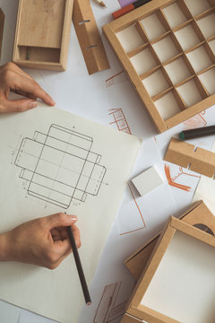 The designer develops, draws sketches for eco-packaging, cardboard boxes. 