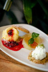 gourmet mango ice cream with redcurrant sauce dessert on plate