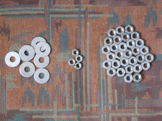 tuercas metálicas distintos tamaños y anillas, de metal, para enroscar en tornillos y ganchos para colgar cuadros, ensamblar muebles y obras de casa