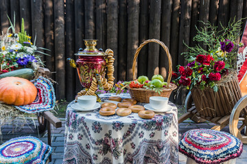 Table with a samovar, cups, bagels and a basket of apples