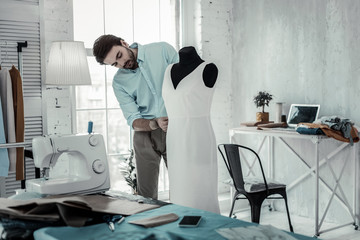 Obraz premium Attentive young designer preparing dress for show