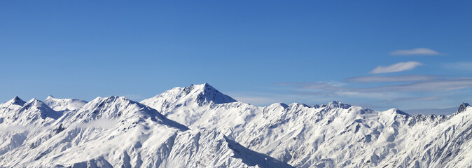Panoramic view on snowy mountains in sunny day