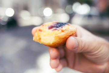 Traditional portuguese dessert in man's hand. Pastel de Nata.