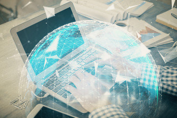 Multi exposure of businessman working on laptop on background. International business hologram in front. Concept of success.
