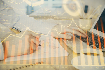 Multi exposure of stock market graph with man working on laptop on background. Concept of financial...