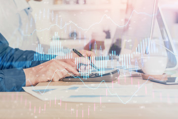 Forex graph with businessman working on computer in office on background. Concept of hardworking. Closeup. Multi exposure.