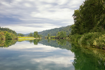 Original photograph of tree line reflections in a lake as smooth as glass