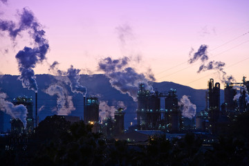 Smoking chimney at sunset on industrial buildings complex, Algeciras, Cadiz province, Andalusia, Spain