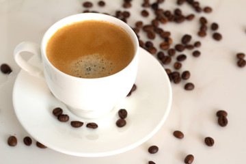 white cup with black coffee and coffee beans
