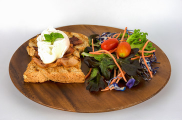 Homemade meal, Organic egg benedict with fresh salad on wood plate for healthy breakfast in white background