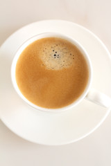white cup with black coffee on a white background close-up