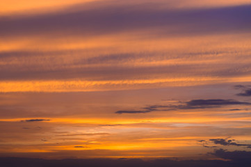 Naklejka na ściany i meble Abstract nature background. Dramatic sunset sky in the clouds saturated with bright colors of orange and yellow. Contrast Low Key