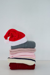Pile sweater with Santa hat on table