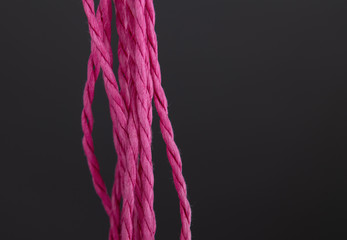 Close up of pink raffia cord on grey background