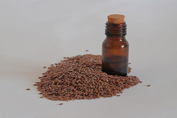 Flax seeds and linseed oil in bottle on white background