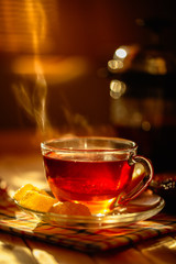  A cup of tea with lemon and marmalade on the table.