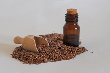 Flax seeds and linseed oil in bottle on white background