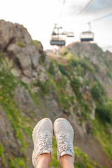 Close-up of female legs in sneakers on the grass outdoors in the park