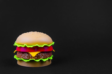 fast food. plastic hamburger on a black background