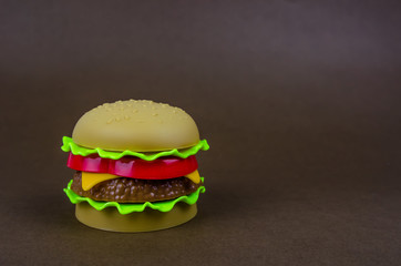 fast food. plastic hamburger on a brown background