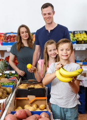Positive children holding delicious bananas