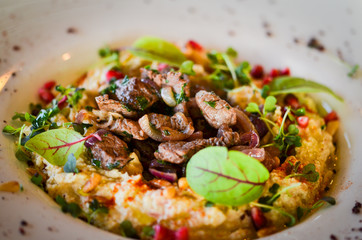lebanese hummus dish with fresh vegetables, beef meat & pomegranate seeds