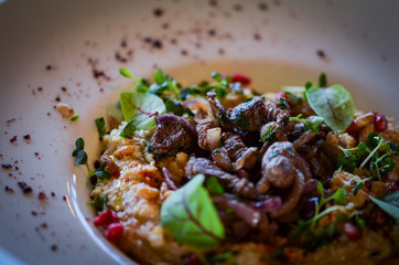 lebanese hummus dish with fresh vegetables, beef meat & pomegranate seeds