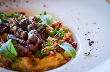 lebanese hummus dish with fresh vegetables, beef meat & pomegranate seeds