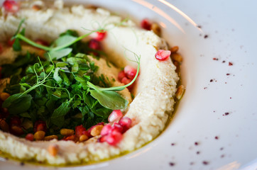 lebanese hummus dish with fresh vegetables, beef meat & pomegranate seeds